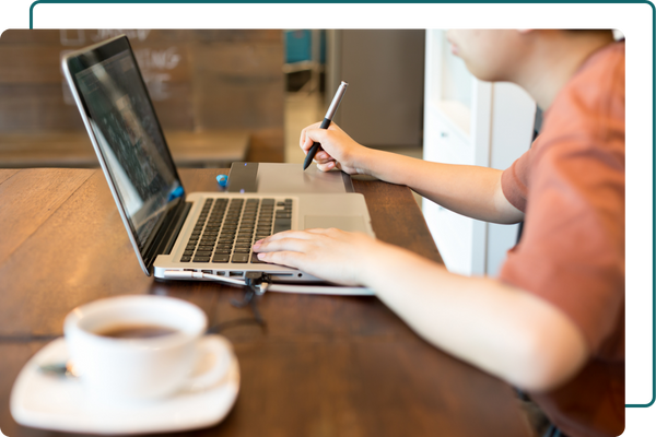 Man using a laptop and taking notes